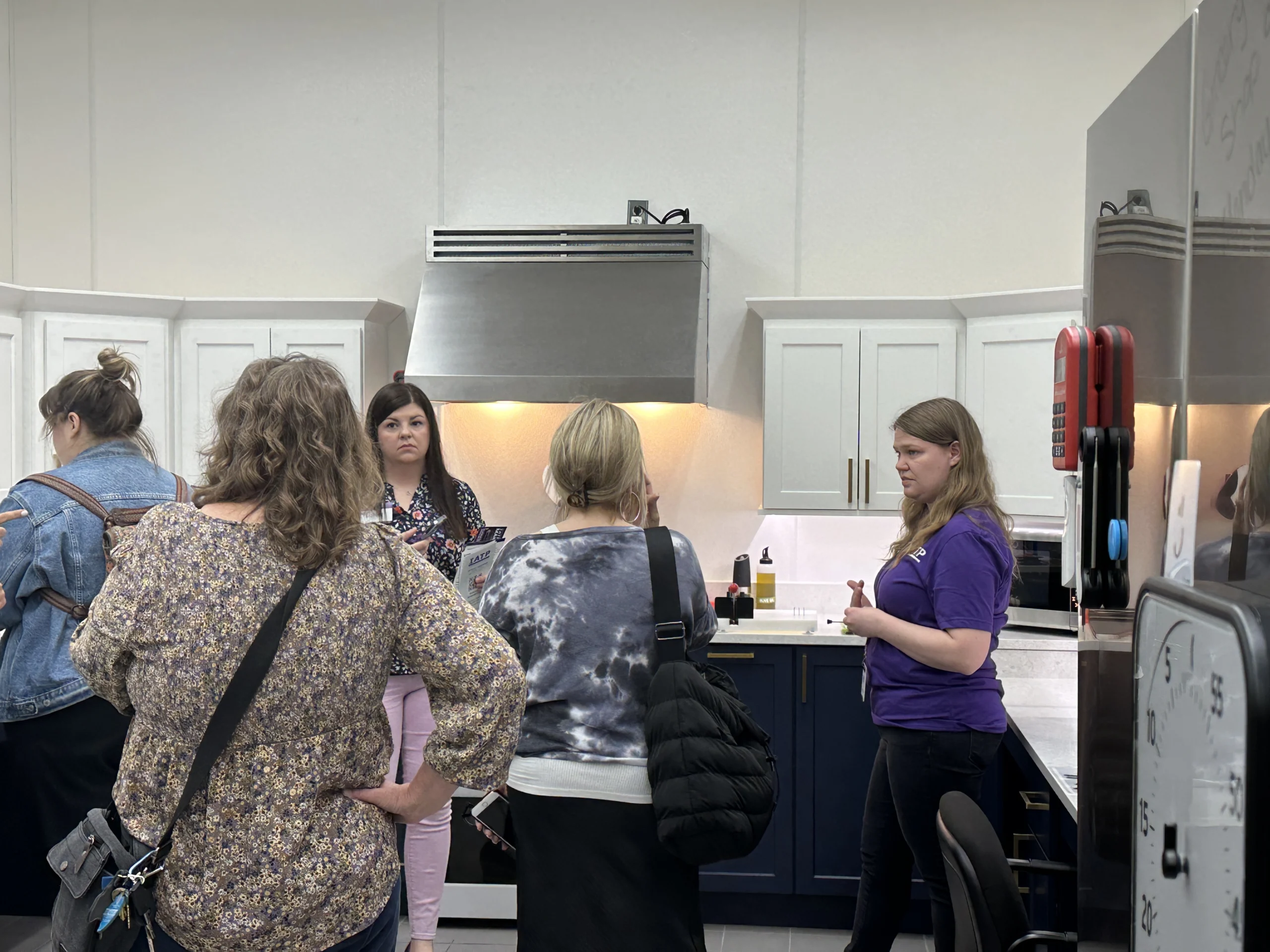IATP Chef Trainer standing in the Tech Kitchen with a group of visitors.