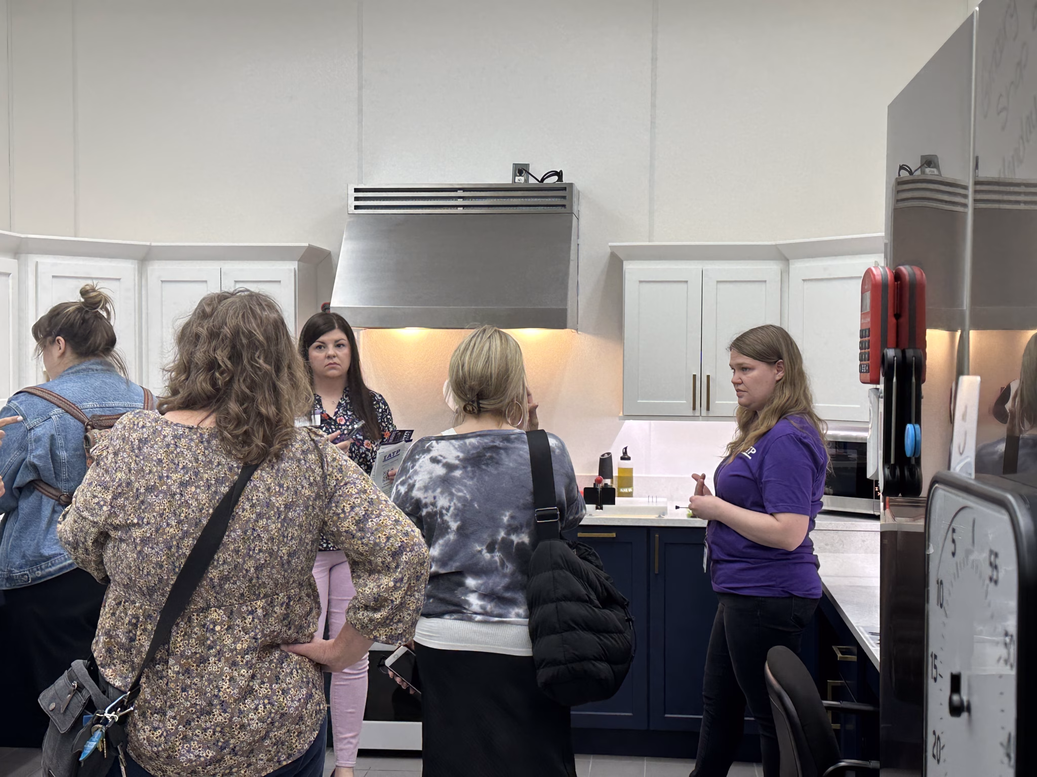 IATP Chef Trainer standing in the Tech Kitchen with a group of visitors.
