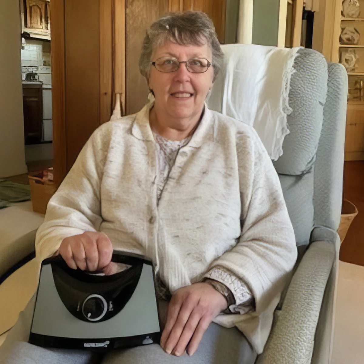 An elderly woman using a magnification device to color a floral page at a table