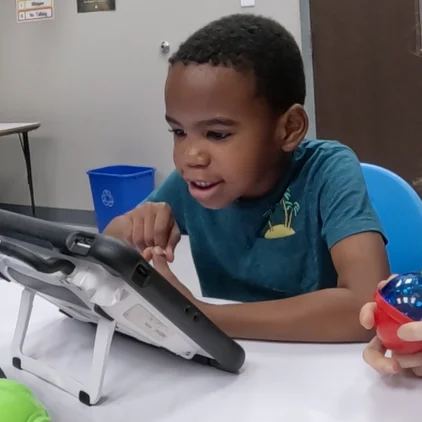 Child engaged with a tablet at a table