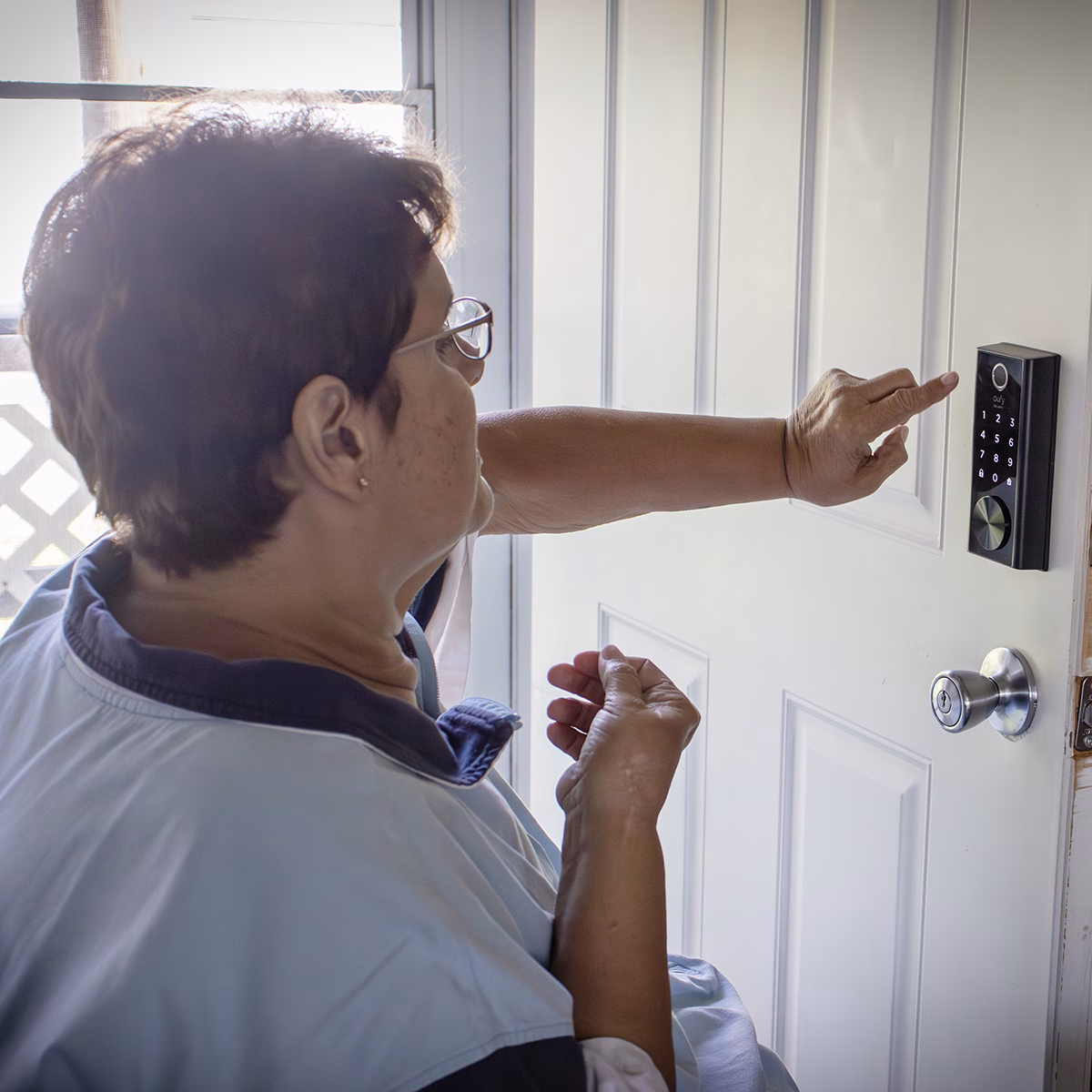 Person using a digital keypad lock on a white door Person using a digital keypad lock on a white door