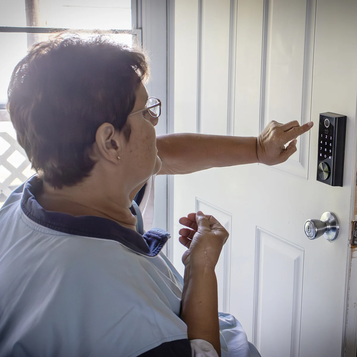 Person using a digital keypad lock on a white door