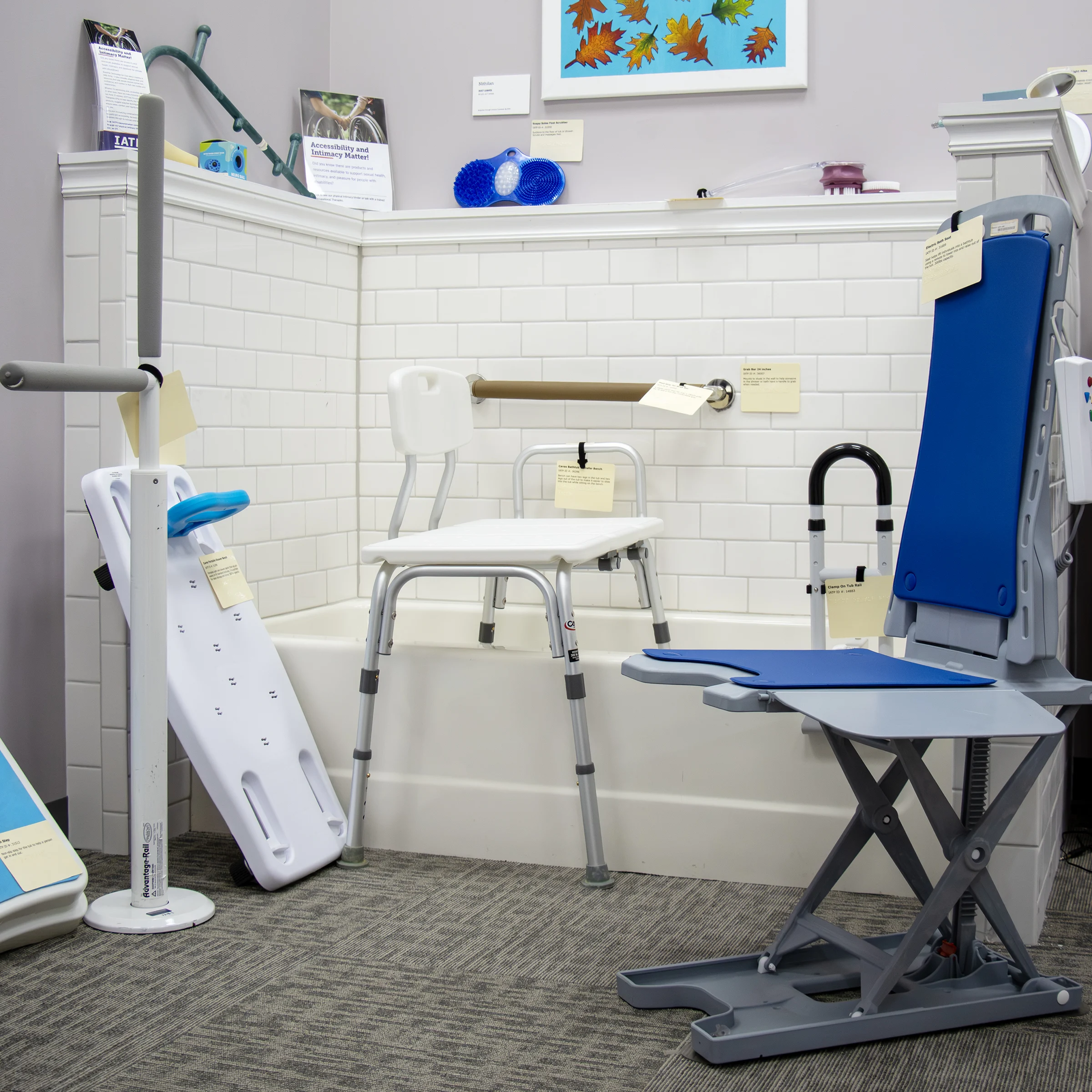 A display of accessible bathroom aids with a bath chair, transfer board, grab bar, and shower chair in IATP’s Demonstration Center