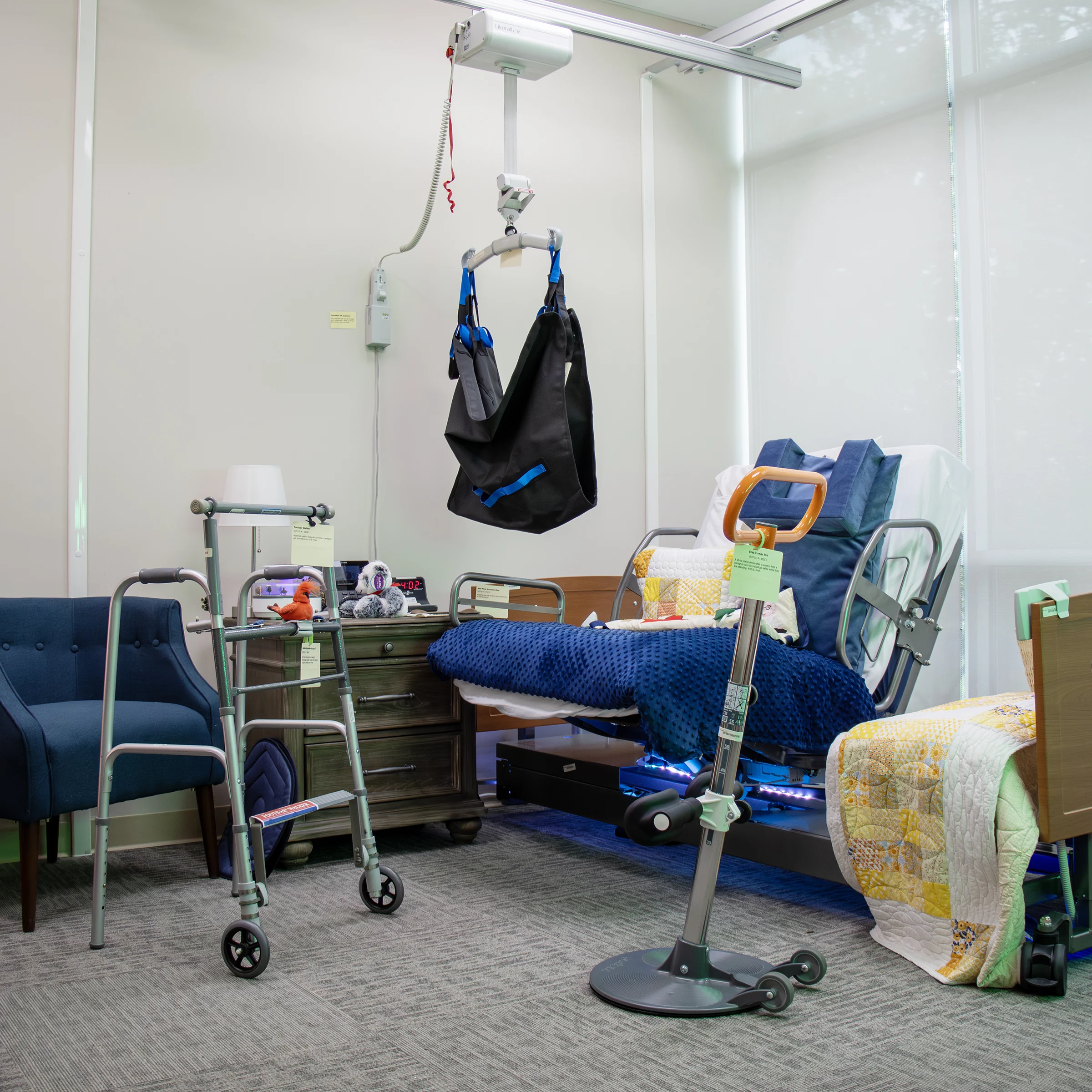 Hospital bed, lifting hoist, walker, bedside table, and chair in IATP’s Demonstration Center