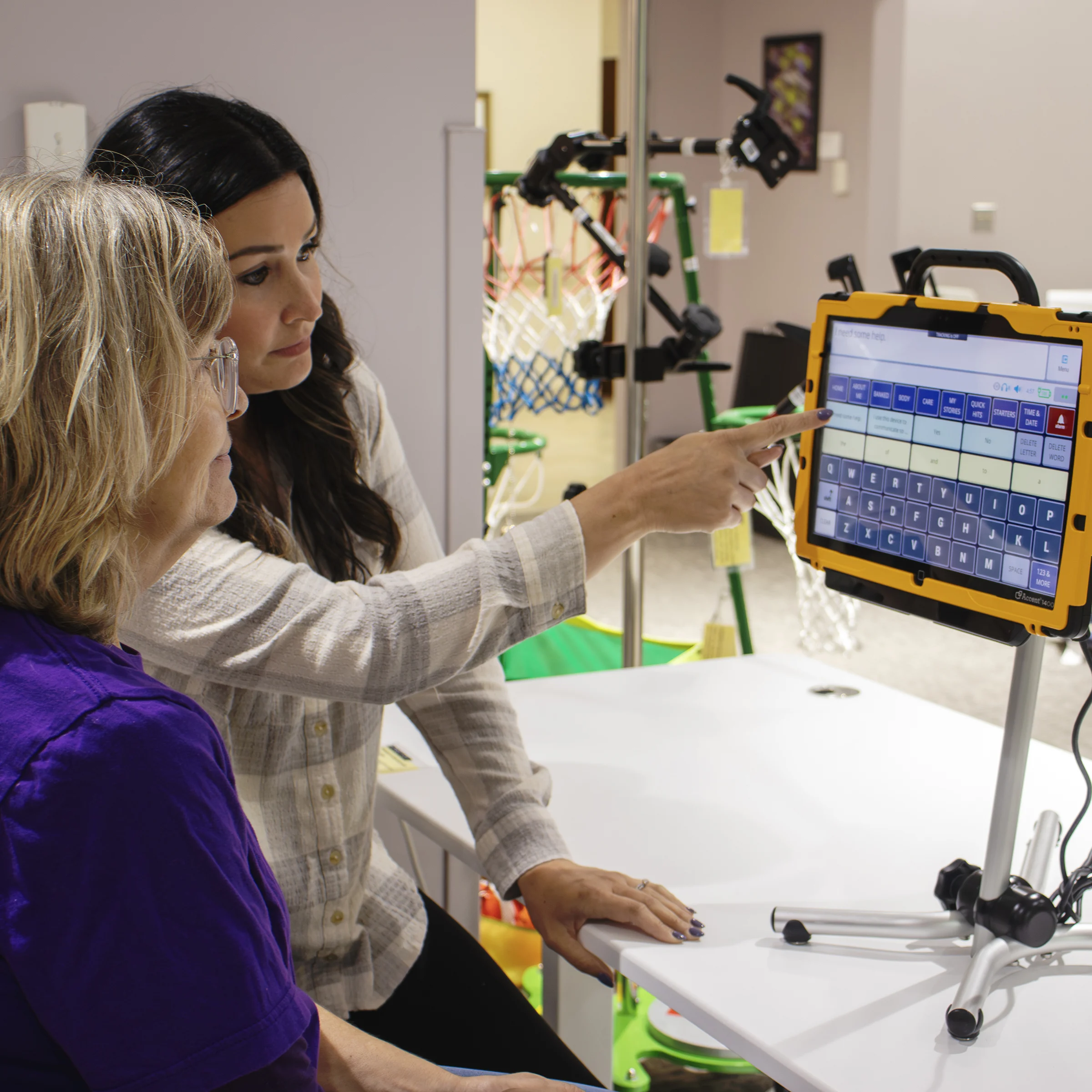 two people sitting in front of a communication device learning how the device works.