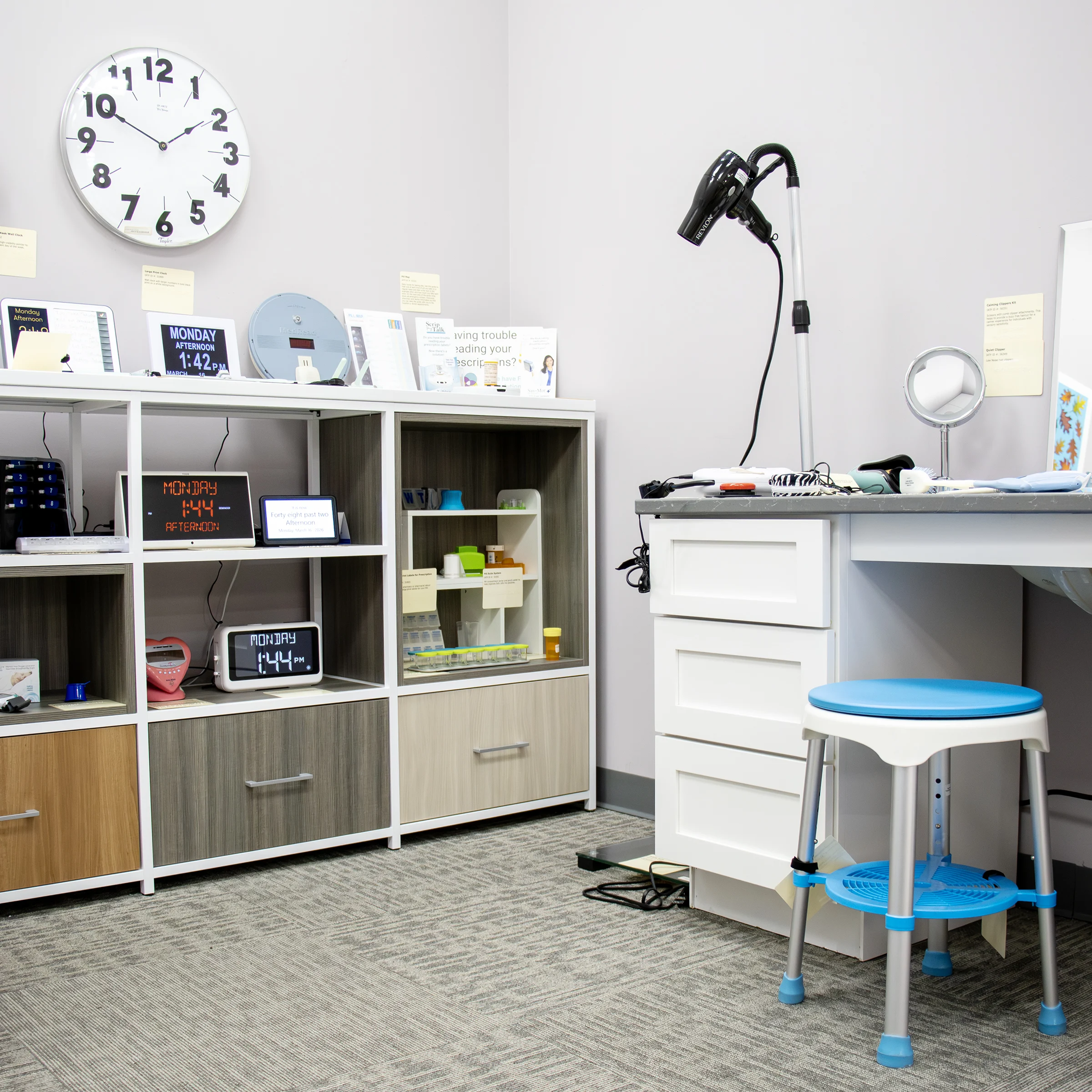 Shelving that shows different accessible clocks, pill organizers, accessible mount for a hair dryer and other accessible daily living devices in IATP’s Demonstration Center.