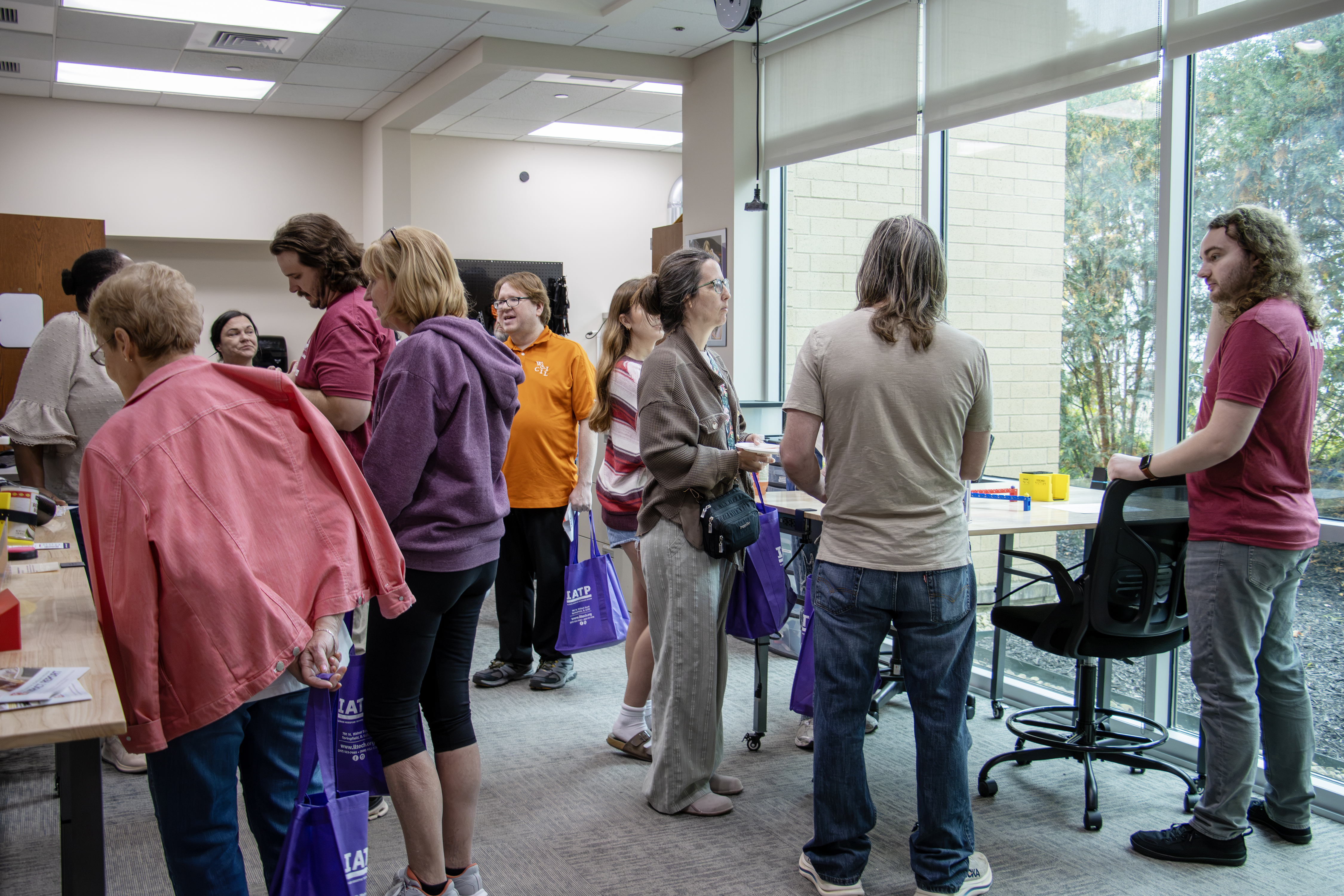 A group of people gathers and talks in the IATP makers space