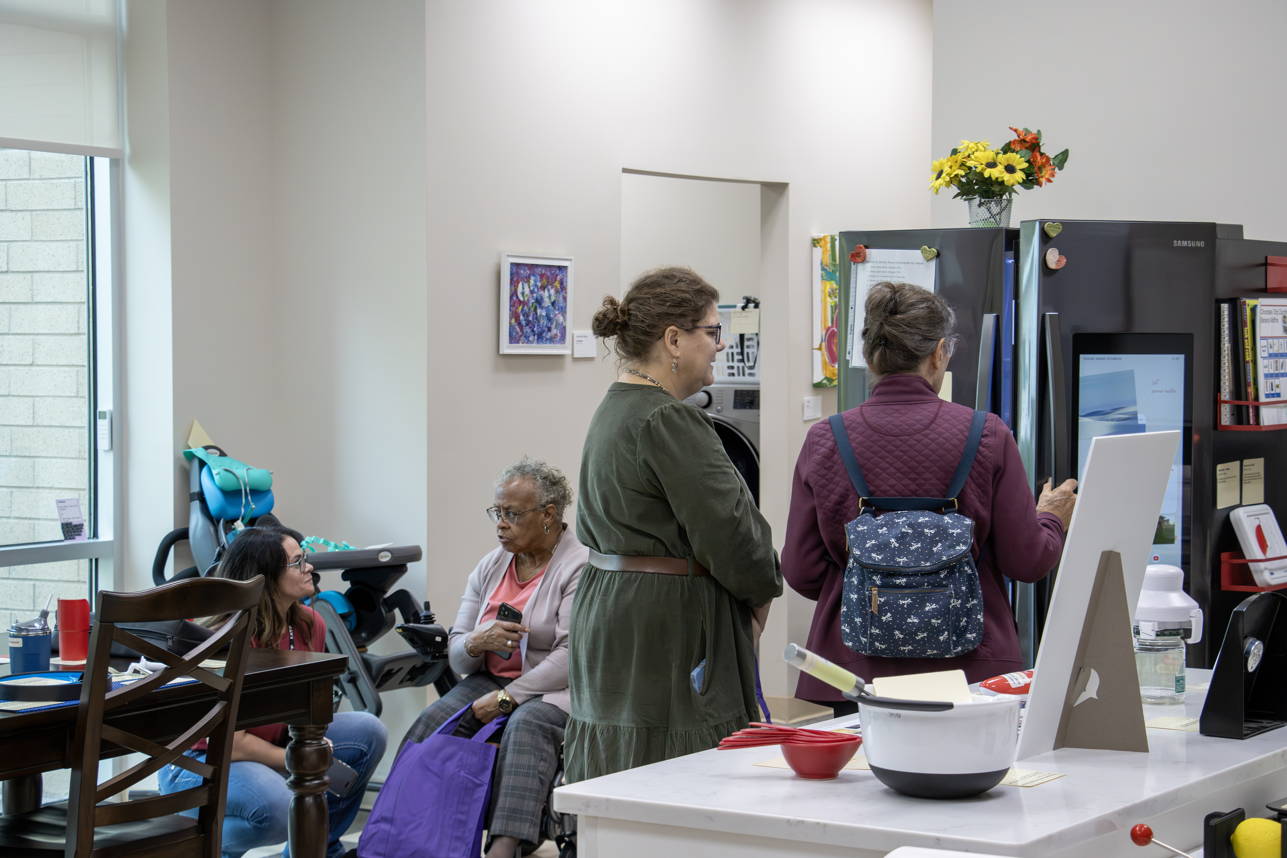 Four women gather in a in the IATP Smart Home kitchen