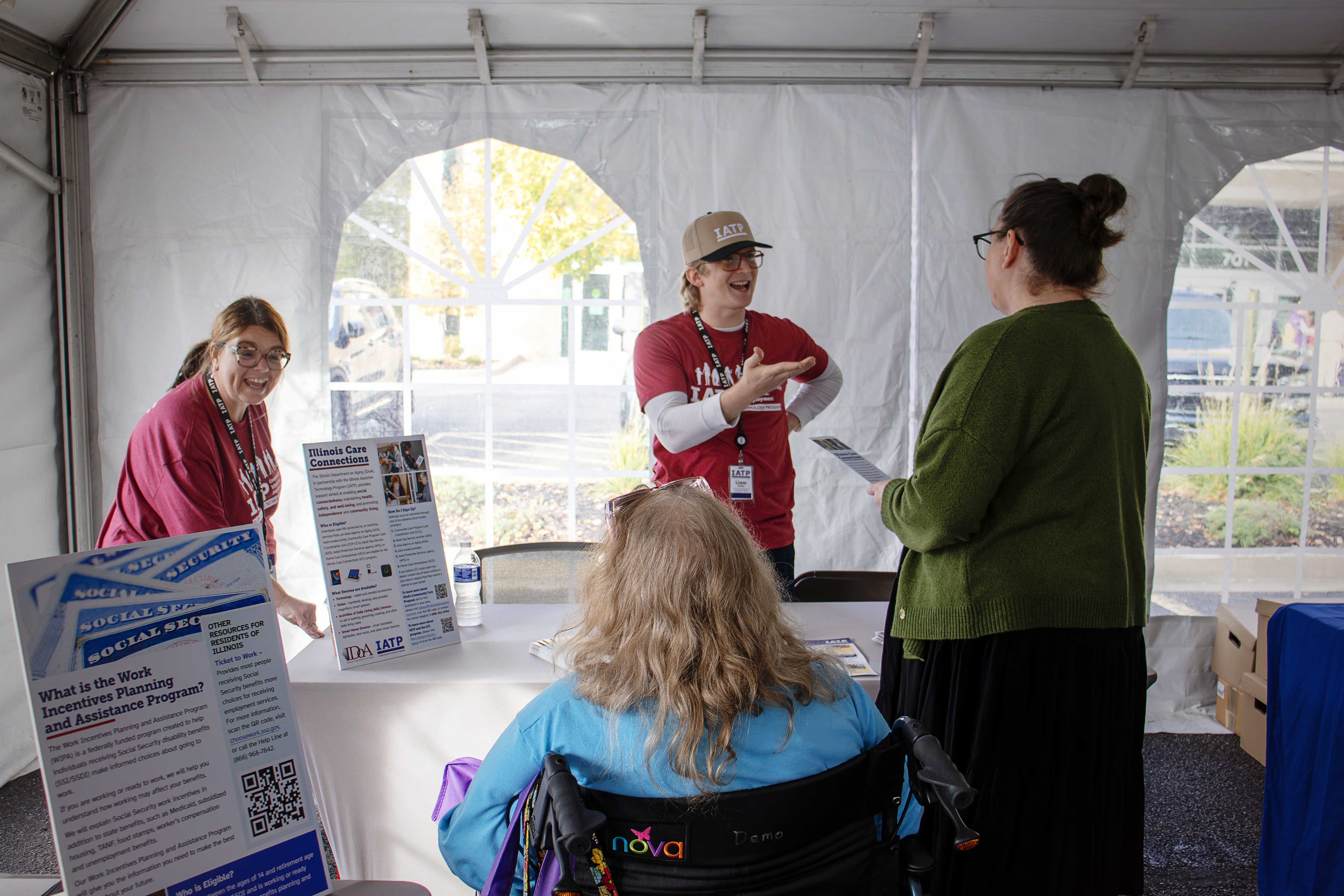IATP staff members talk with visitors inside the outdoor tent at the IATP Resource Fair